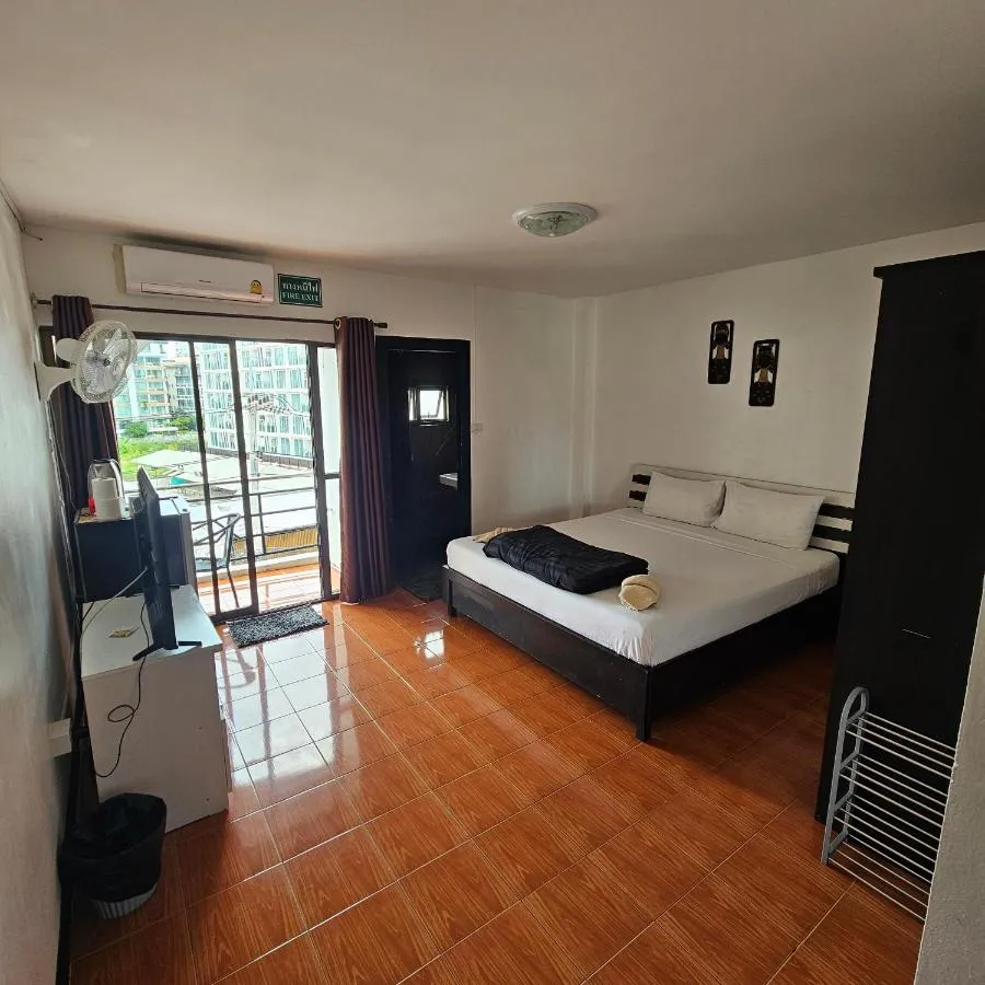 A room at Secrets Pattaya with the balcony door open to a city view