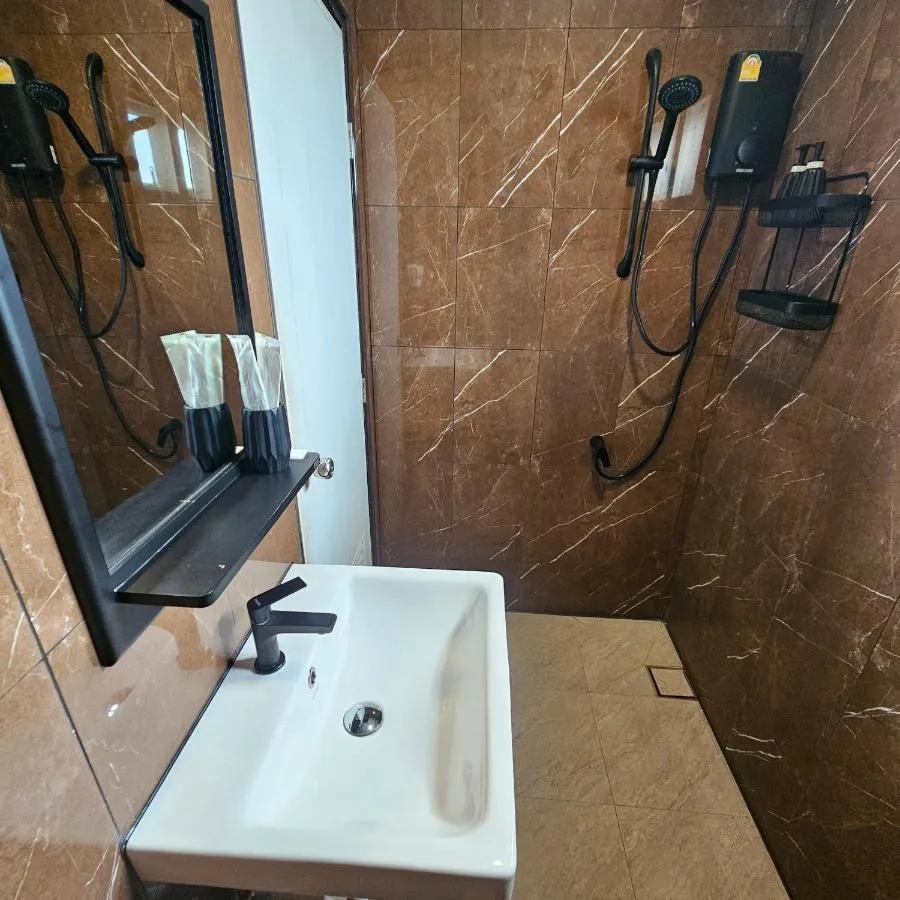Marble-tiled ensuite bathroom with a walk-in shower and sink